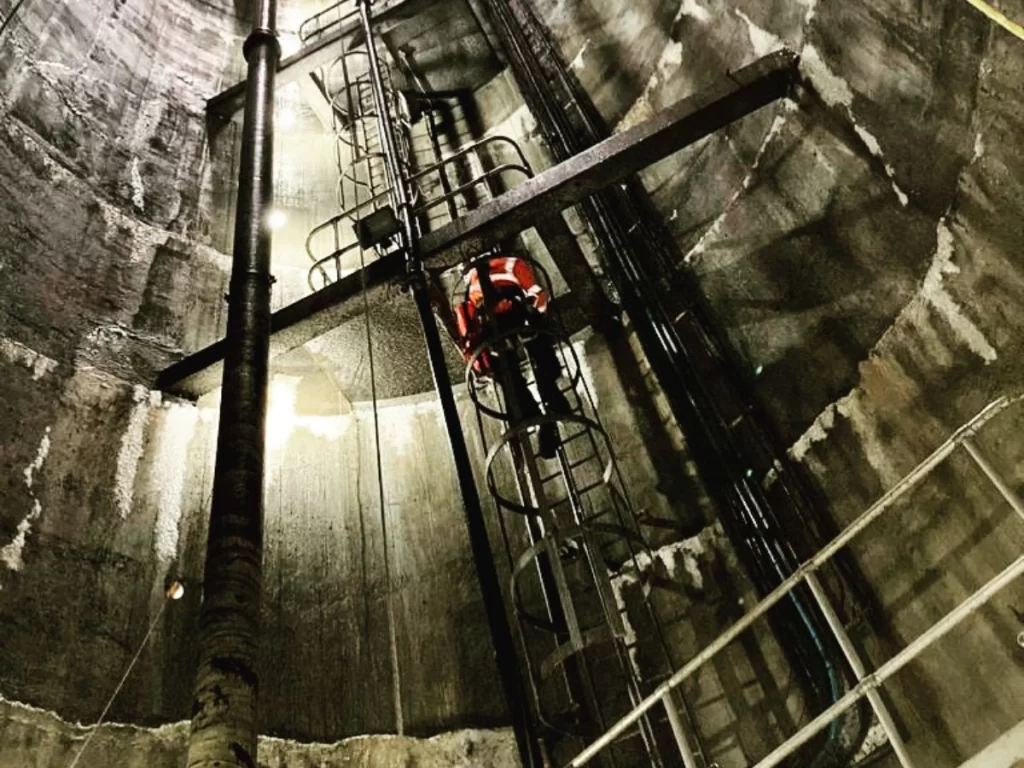 Person hanging through a rope going down a tunnel