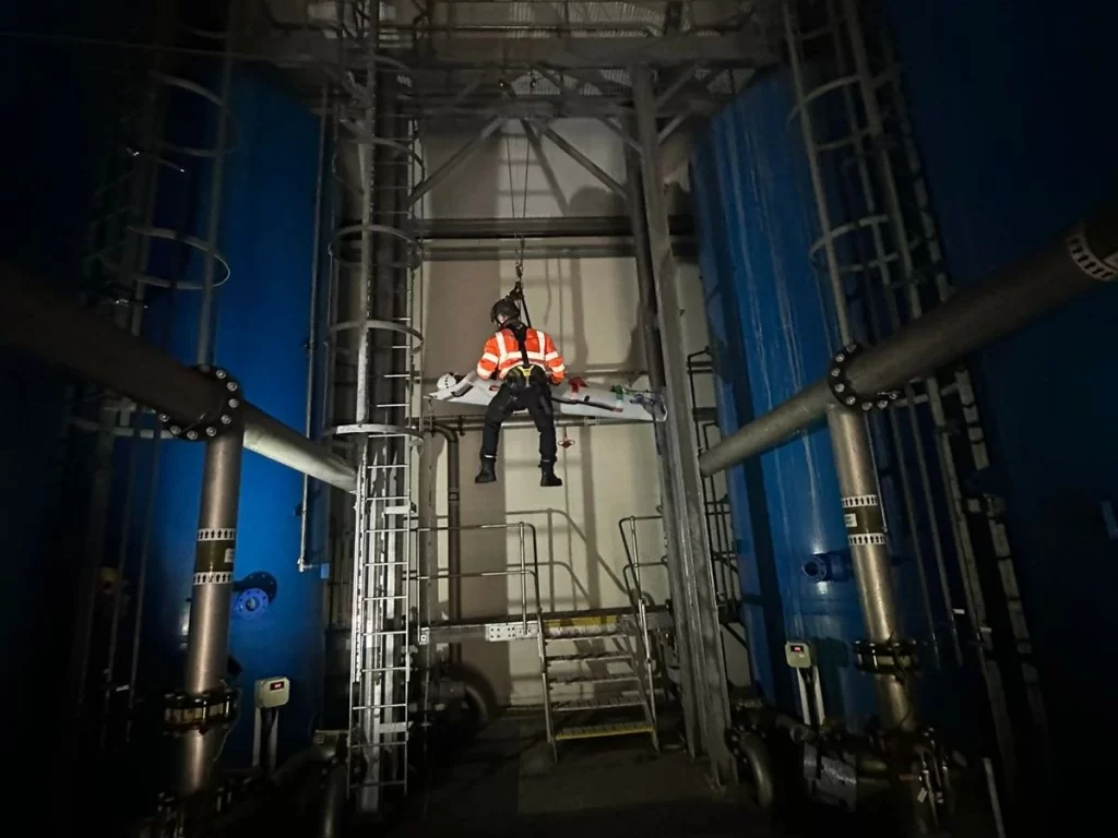 Rescue team hanging through a rope and going up for safety after rescue.