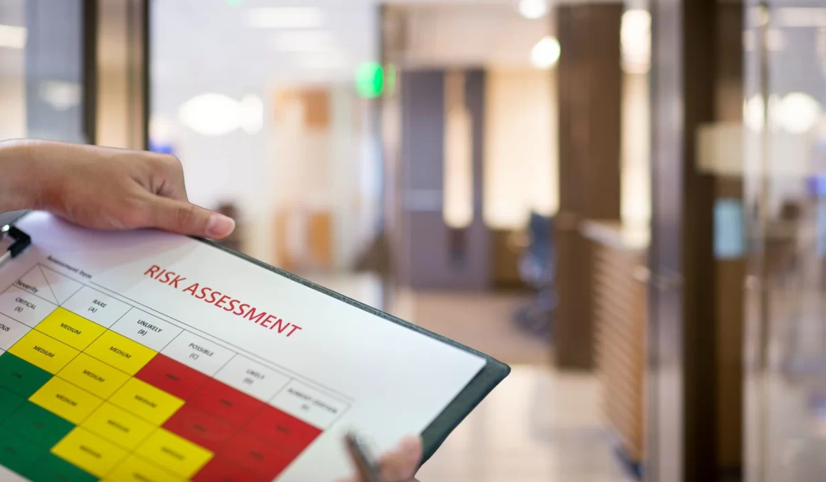 A person holding a graph showing level of risk and an office background